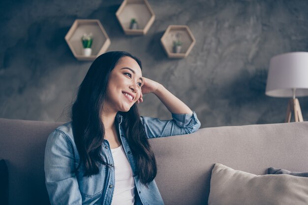 ragazza seduta sul divano guardando alla finestra