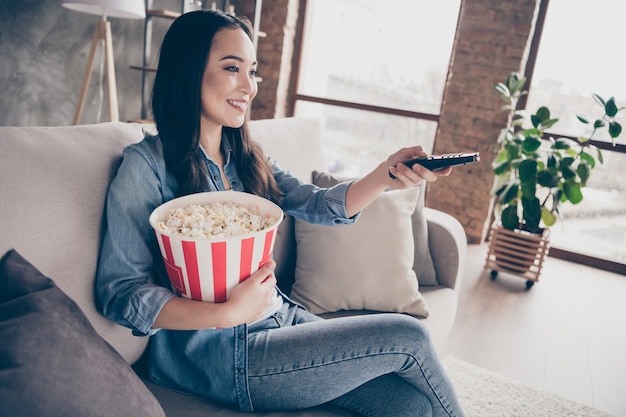 ragazza seduta sul divano guardando la tv