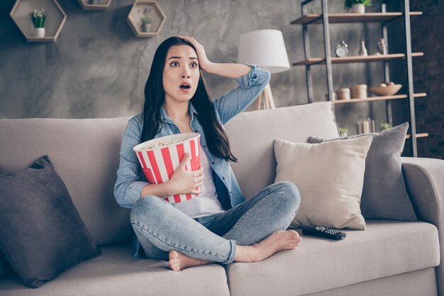 ragazza seduta sul divano guardando la tv