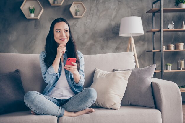 ragazza seduta sul divano tenendo il telefono