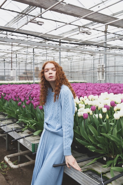 Ragazza seduta sul tavolo con fiori