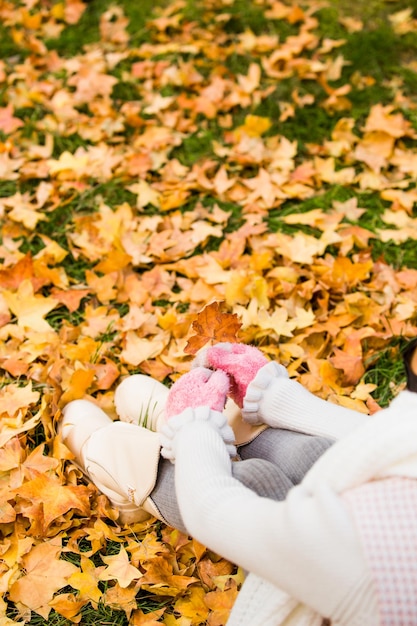 Ragazza seduta sulle foglie in autunno