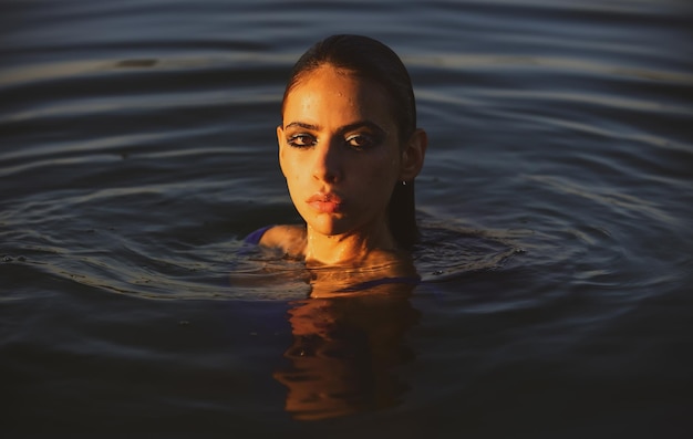 Ragazza sensuale in acqua. Donna di bellezza. Ritratto di moda. Spiaggia estiva.