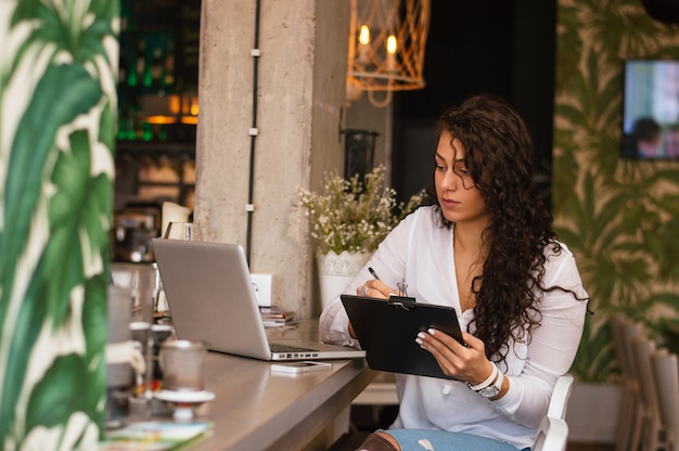 Ragazza seria che fa lavoro di ufficio dall&#39;ufficio coworking