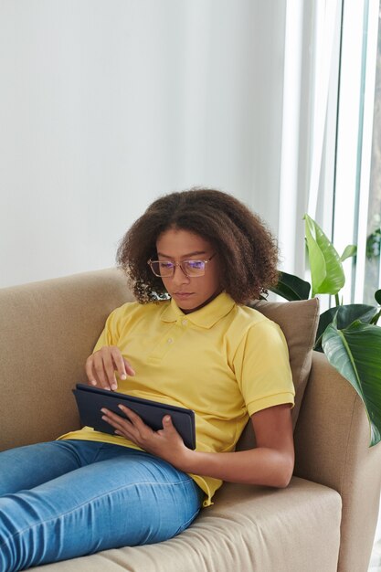 Ragazza seria che lavora al computer portatile