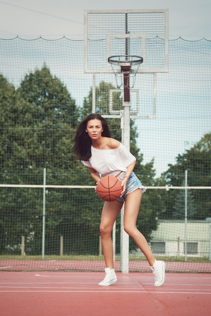 Ragazza sexy che gioca a basket