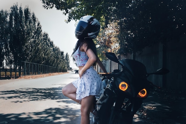 Ragazza sexy esile che posa in moto