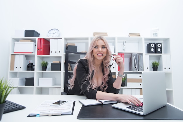 Ragazza sexy sul posto di lavoro davanti al computer