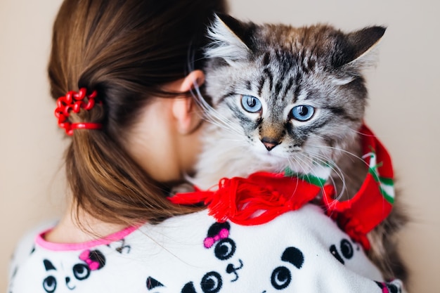 ragazza si alza e tiene il gatto tra le braccia