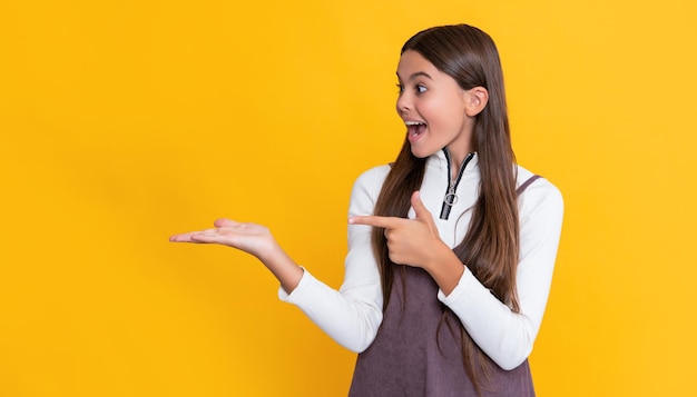 Ragazza sorpresa con i capelli lunghi su sfondo giallo