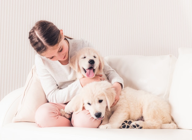 Ragazza sorridente che abbraccia i cuccioli