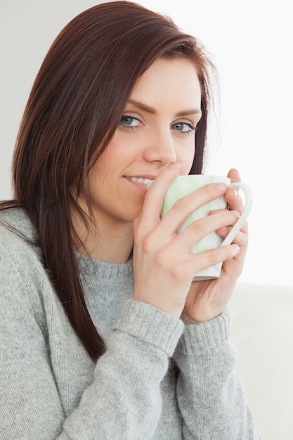 Ragazza sorridente che beve una tazza di caffè