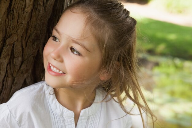 Ragazza sorridente che distoglie lo sguardo nel parco