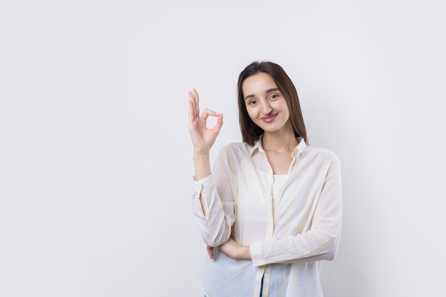 Ragazza sorridente che fa segno OK con la mano