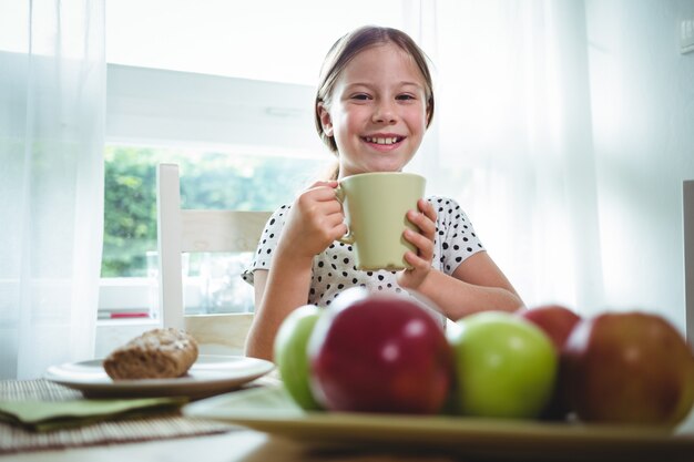 Ragazza sorridente che mangia caffè