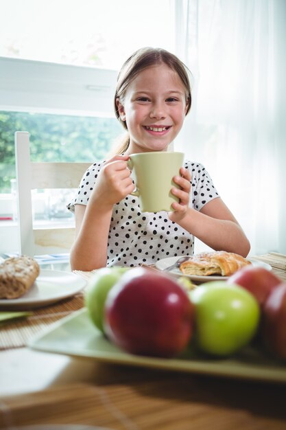 Ragazza sorridente che mangia caffè