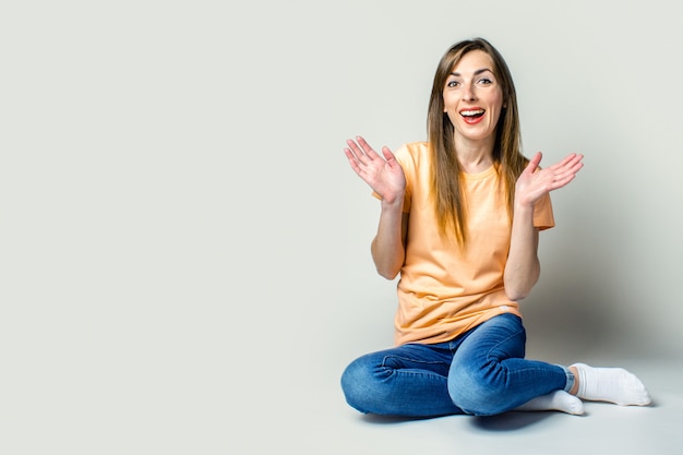 Ragazza sorridente che si siede sul pavimento