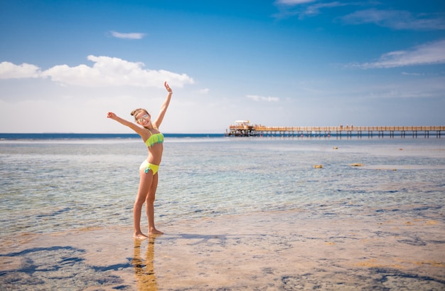 Ragazza sorridente che sta nel mare caldo