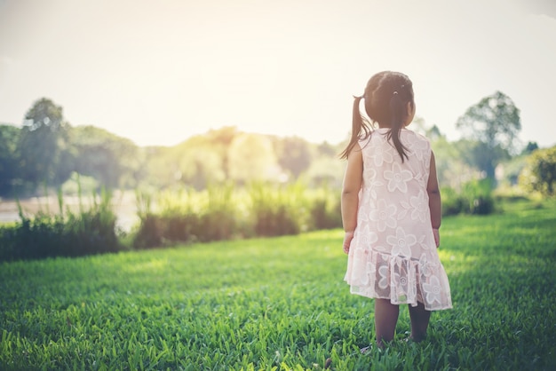 Ragazza sorridente che sta nel parco, tempo felice