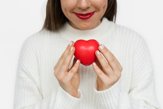 Ragazza sorridente che tiene un cuore di ricerca