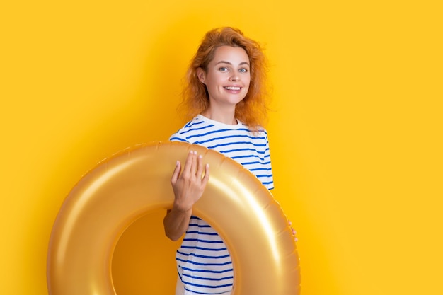 Ragazza sorridente con anello gonfiabile isolato su sfondo giallo vacanze estive