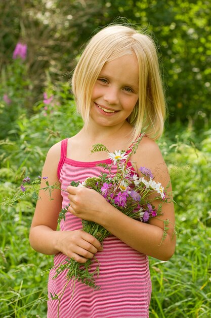 Ragazza sorridente con fiori all'aperto