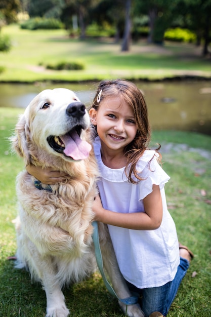 Ragazza sorridente con il suo cane nel parco