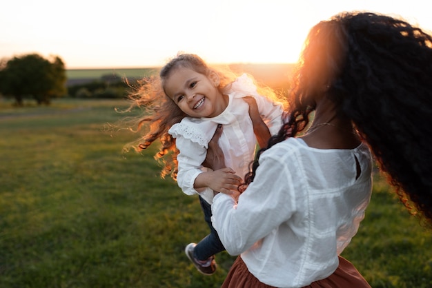 Ragazza sorridente della holding della madre di vista laterale