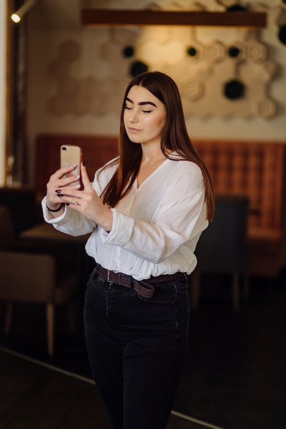 Ragazza sorridente di trascorrere del tempo in un caffè di strada utilizzando gadget digitali