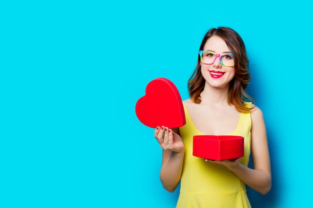 Ragazza sorridente felice con scatola a forma di cuore