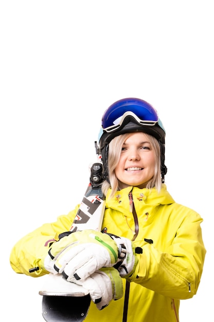 Ragazza sorridente in casco che tiene gli sci