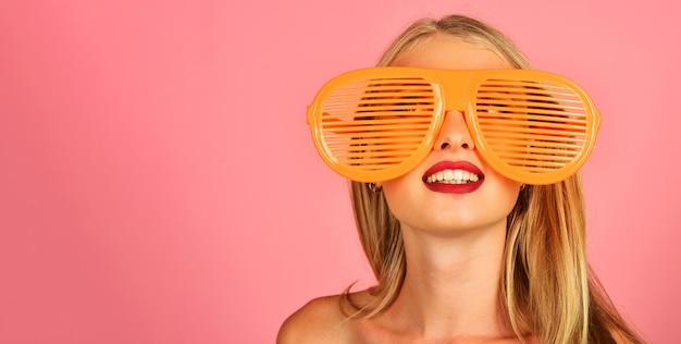 Ragazza sorridente in elegante otturatore arancione tonalità occhiali da sole estate spiaggia viaggio e concetto di vacanza