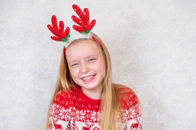 Ragazza sorridente nel cerchio dei capelli di Natale