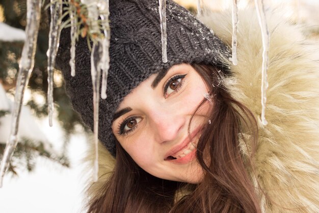 Ragazza sorridente nel parco in inverno con molta neve intorno