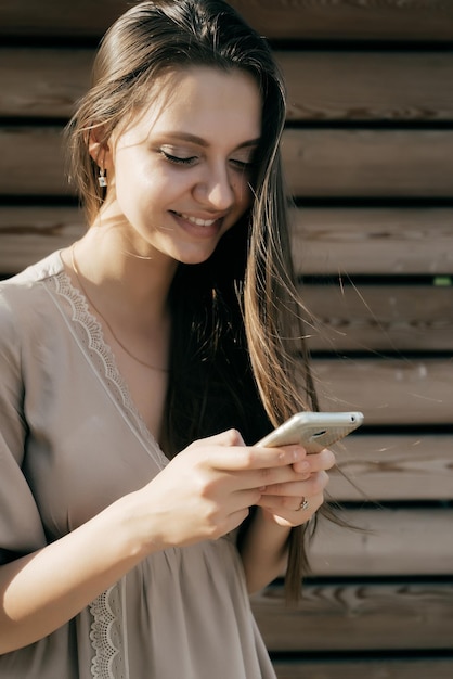 Ragazza sorridente per corrispondenza con qualcuno al telefono