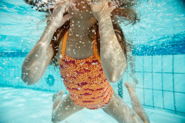 Ragazza sotto l'acqua in piscina