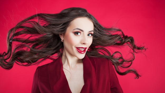 Ragazza sotto shock sulla parete rosa. Giovane bella donna con i capelli.