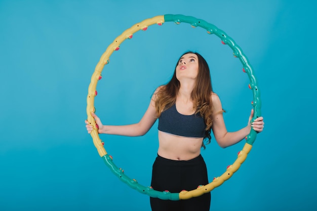 ragazza sportiva allegra con hula hoop su sfondo blu