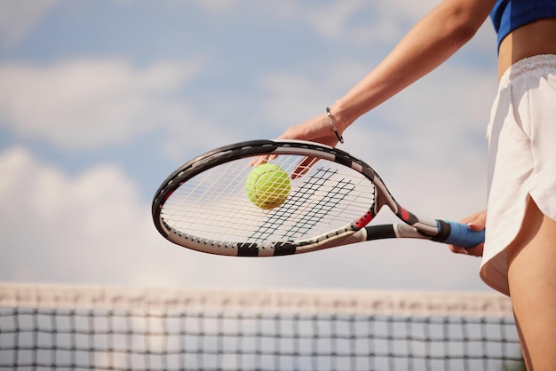 Ragazza sportiva che si prepara a servire la pallina da tennis Vista ravvicinata della bella ragazza che tiene la pallina da tennis e la racchetta