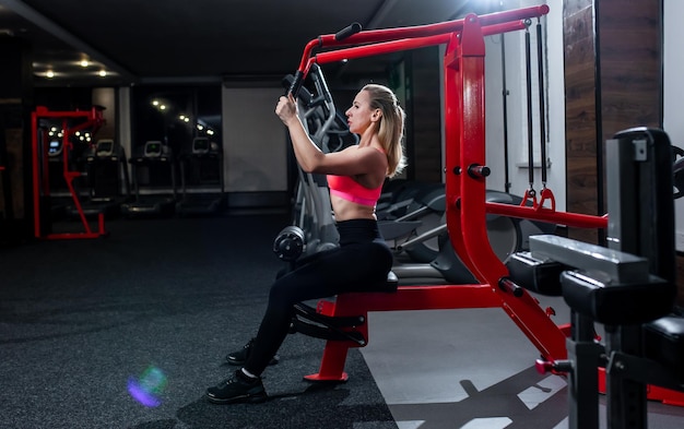 Ragazza sportiva facendo esercizi in palestra Ragazza va a fare sport in palestra