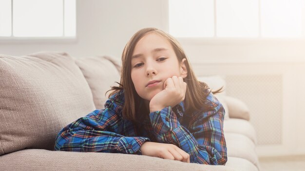 Ragazza stanca seduta sul divano di casa