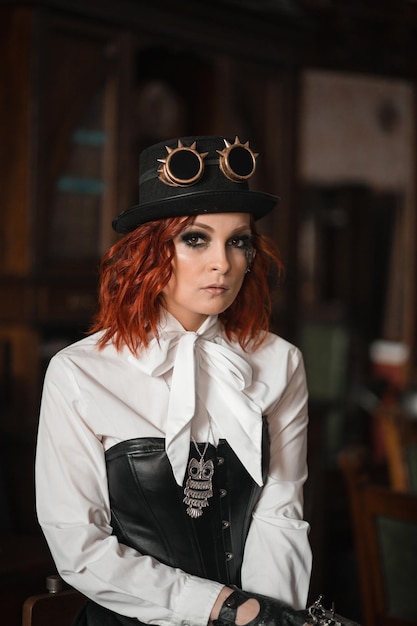 Ragazza Steampunk In camicia bianca corsetto in pelle cappello occhiali rotondi ritratto