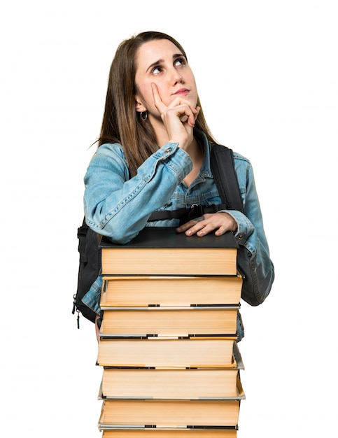 Ragazza studentessa adolescente con un sacco di libri e di pensiero