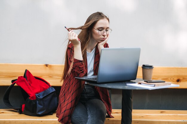 Ragazza studentessa che studia duro esame e dorme sui libri nel caffè di strada ragazza stanca che lavora