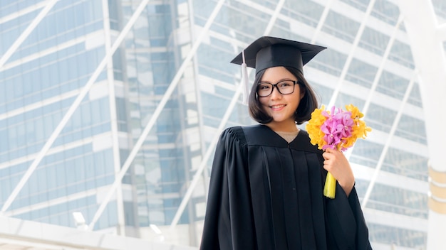 ragazza studentessa in laurea con bouquet di fiori