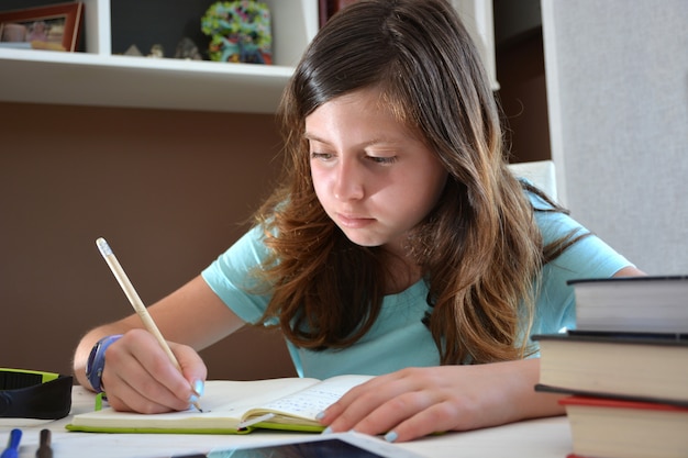 Ragazza studiando alla sua scrivania con un tablet