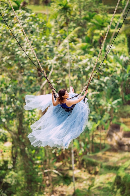 Ragazza su un'altalena. Sfondo di terrazze di riso. Ubud. Bali. Indonesia