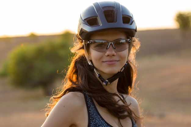 Ragazza su una mountain bike in fuoristrada bellissimo ritratto di un ciclista al tramonto