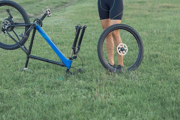 Ragazza su una mountain bike su fuoristrada bellissimo ritratto di un ciclista al tramonto Ragazza fitness guida una moderna mountain bike in fibra di carbonio in abbigliamento sportivo Ritratto del primo piano di una ragazza con casco e occhiali