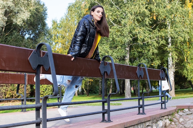 Ragazza sul ponte nel parco autunnale